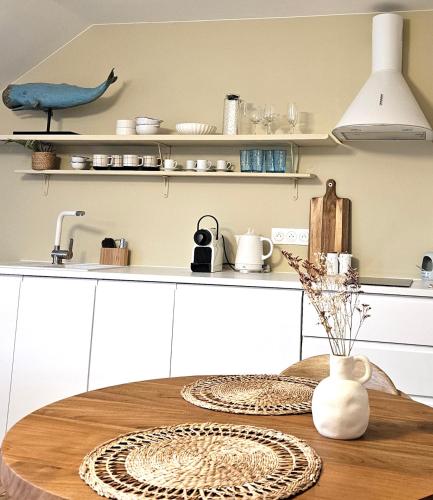 a kitchen with a table with plates on it at Anatoline Audierne Appart'hôtel - Appartements vue Mer - Sea & Harbor Stay in Audierne