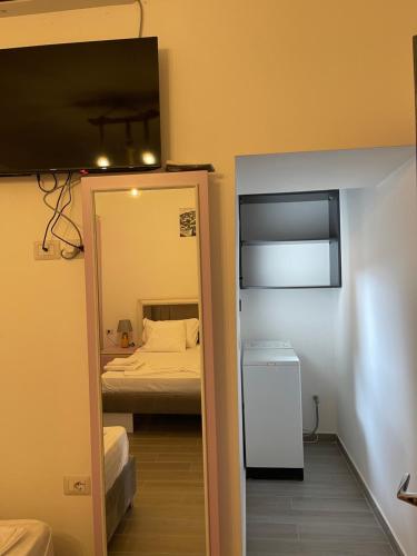a small room with a bed and a mirror at Guest house Doko in Berat