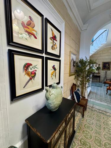 a room with a vase on a table with paintings on the wall at Stylish Boutique Duplex Apartment Home - Orange - 2 Double Bedrooms in Hamrun