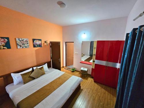 a bedroom with a bed and a red cabinet at KALON ELPIS Tea Estate Villa in Lovedale