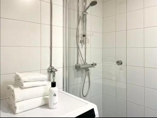 a bathroom with a shower with towels on a table at 7th Heaven in Tampere