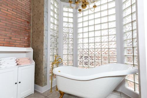 a bathroom with a white tub and windows at Charming School House with Large Pool in Huron