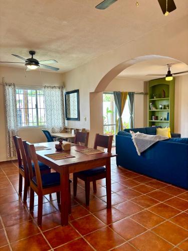 a living room with a table and a blue couch at Casa Las Palmas, comfort and privacy in Mahahual