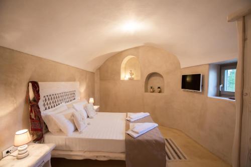 1 dormitorio con cama blanca y ventana en LoveNest, en Akrotiri