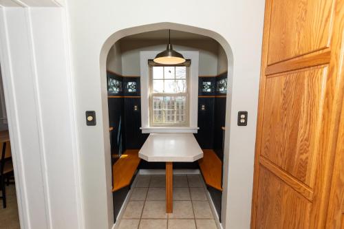 a hallway with a white chair and a window at Charming School House with Large Pool in Huron