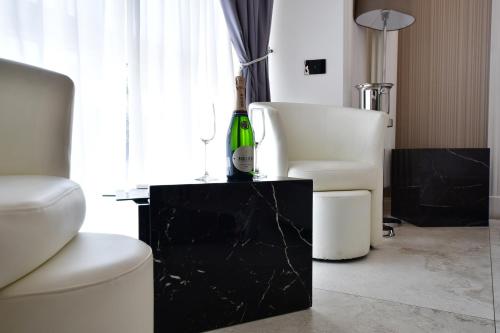 a living room with a white chair and a bottle of wine at Domus De Cinti in Tivoli