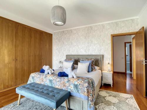 een slaapkamer met een groot bed en een blauwe bank bij Zen House By The Madeira Luxury Collection in Arco da Calheta