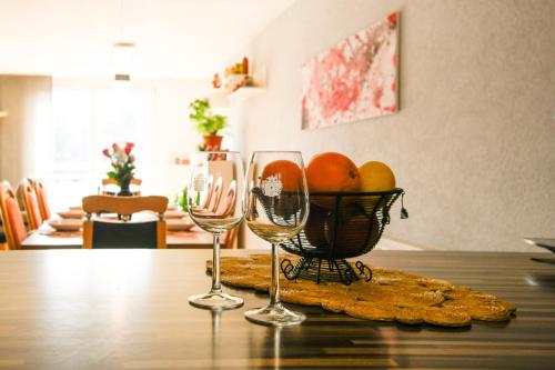 two wine glasses and a basket of fruit on a table at Haus Anna&Lisa in Lauchringen