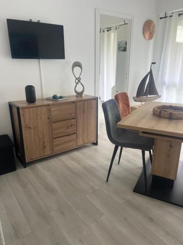 un salon avec une table et une télévision sur un meuble dans l'établissement Whoua Charmant appart Mérignac, à Mérignac