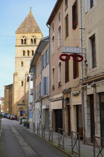 a street with a building with a clock tower at Appartement Cime - Confort & Charme in Saint-Gaudens