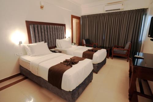 Ένα ή περισσότερα κρεβάτια σε δωμάτιο στο Alleppey Prince Hotel