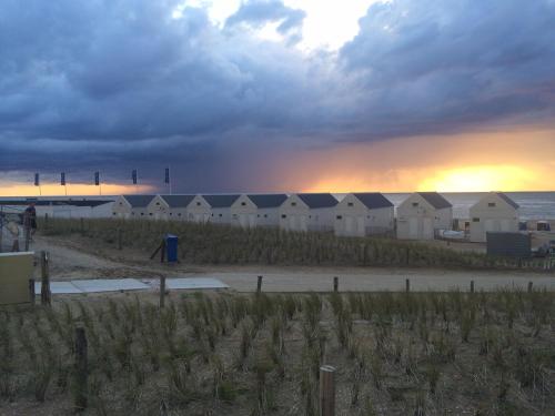 a group of beach huts on the beach at sunset at Beach Hotel Katwijk in Katwijk