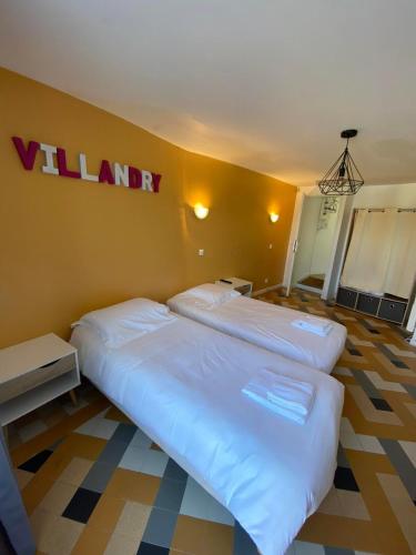 a bedroom with two beds and a wall with avalley sign at Appt 5 personnes - 2 Chambres, terrasse et jardin in Villandry