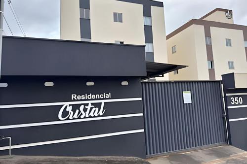 ein schwarz-weißes Gebäude mit einem Tor und einem Gebäude in der Unterkunft Conforto e Praticidade em Araxá in Araxá