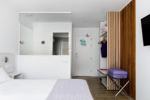 a small bedroom with a bed and a mirror at Hotel hcp in Calella de Palafrugell