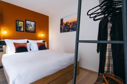 - une chambre avec un grand lit blanc et une chambre avec une échelle dans l'établissement OIQIA • New Yorker, à Toulouse