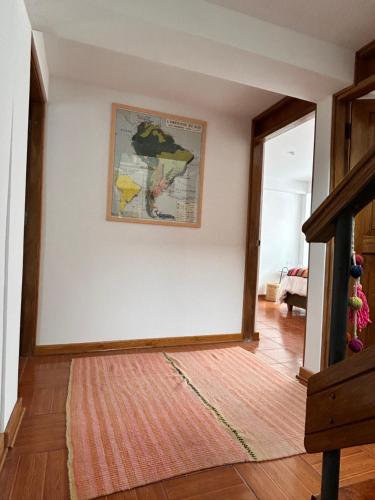 a room with a white wall with a map on it at La Maison Samaï in Urubamba
