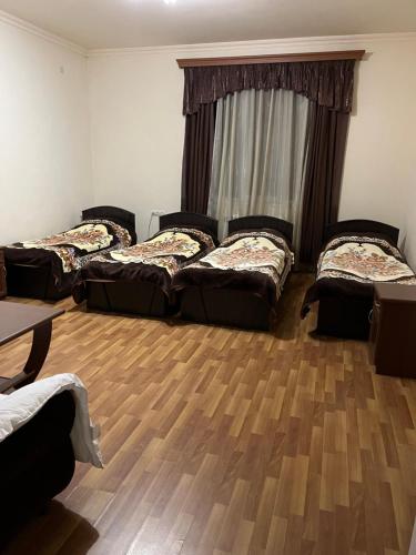 a room with three beds and a wooden floor at Lenko in Goris