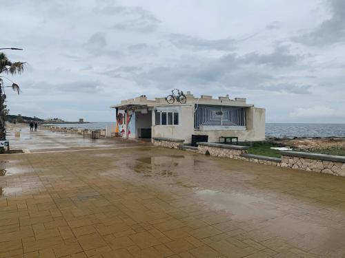 a building on the beach with a bike on it at Casa Ari in Casalabate