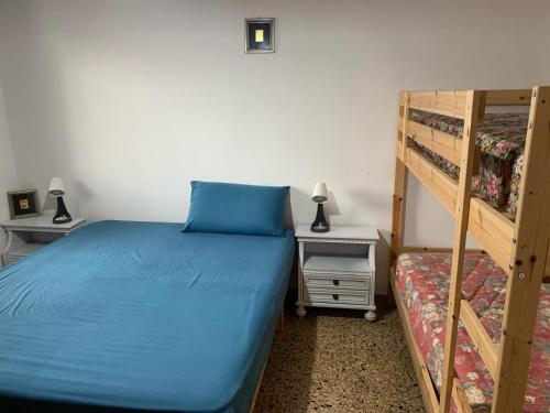 a bedroom with a blue bed and bunk beds at Casa Ari in Casalabate