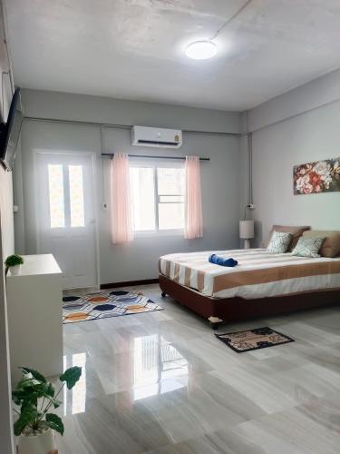 a bedroom with a large bed and two windows at The little home in Bangkok