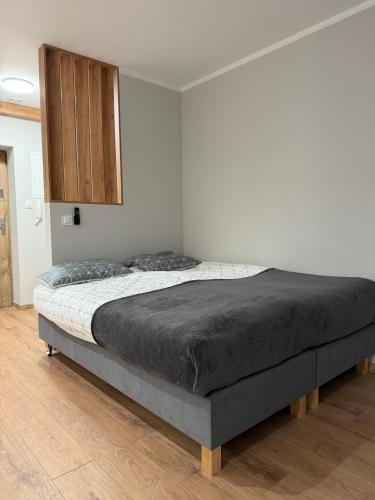 a bed in a bedroom with a wooden cabinet at Apartament Rynek 17 in Krosno