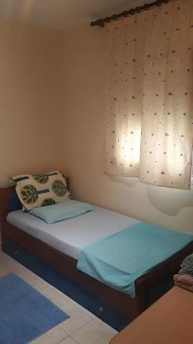 a small bedroom with a bed with a window at Blue lagoon in Skála Foúrkas