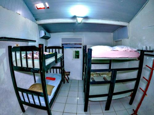 a room with three bunk beds in a room at Casa Wilson in Morro de São Paulo