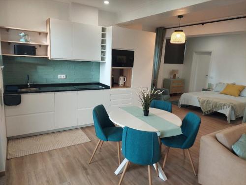 eine Küche und ein Wohnzimmer mit Tisch und Stühlen in der Unterkunft Apartment Studio Espiche near Praia da Luz in Luz