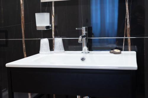 a white sink in a bathroom with a mirror at Flat Urban Suites in Rome