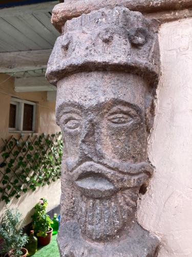 a statue of a face on the side of a building at La Maison Samaï in Urubamba