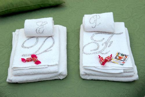 two white towels with red bows on them on a table at Divine Bed & Breakfast in Rome