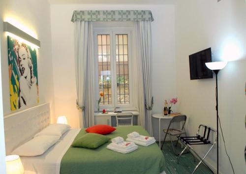 a bedroom with a bed and a table and a window at Divine Bed & Breakfast in Rome