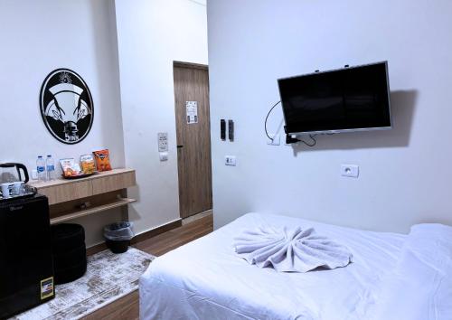 una camera da letto con un letto e una TV a schermo piatto di The 5 Inn - Pyramids a Il Cairo