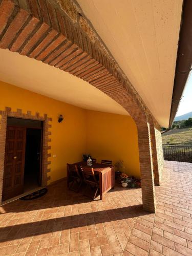 a patio with a wooden table and an open door at Le Querce in Montecchio