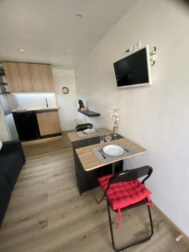 un salon avec une table et une chaise rouge dans l'établissement Studio cosy Cannes à 250 m de la plage, pointe Croisette, à Cannes