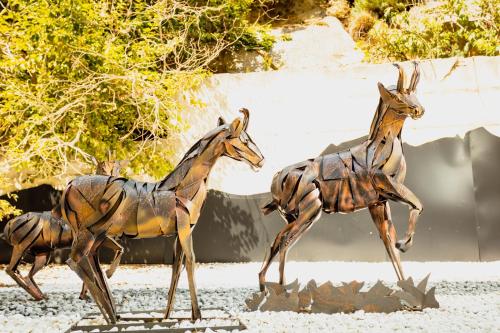 a statue of three giraffes walking on the ground at Hôtel Le Grand Tétras in Font-Romeu