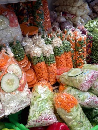 a pile of vegetables in plastic bags on display at La Maison Samaï in Urubamba