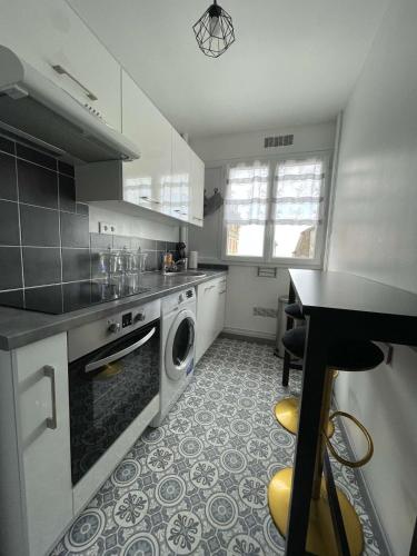 une cuisine avec une machine à laver et un lave-vaisselle dans l'établissement La Suite Féline - vu mer exceptionnelle !, à Villers-sur-Mer