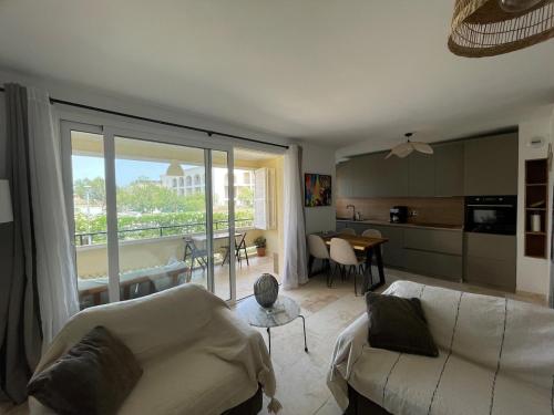 un salon avec un canapé blanc et une cuisine dans l'établissement Anaïs, à LʼÎle-Rousse