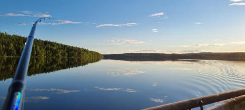 a view of a lake from a boat with a rod at Wild Power Guesthouse in Lycksele