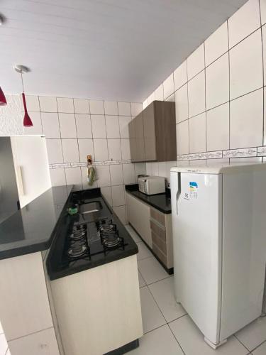a kitchen with a stove and a white refrigerator at Recanto Liberdade in Sinop