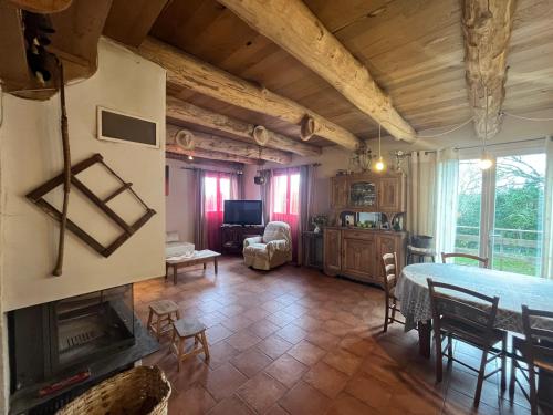 un salon avec une table et une cheminée dans l'établissement Le Cambou, à Campestre-et-Luc
