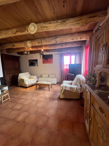 - un salon avec des canapés et une télévision dans une maison dans l'établissement Le Cambou, à Campestre-et-Luc