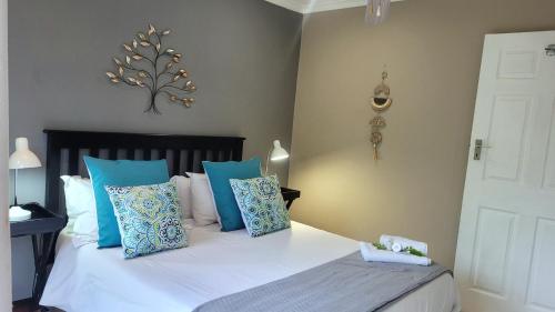 a bedroom with a bed with blue and white pillows at Suite 10- Deja' Blu Bed and Breakfast- East London in East London