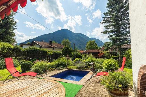 a patio with a table and chairs and a pool at Landhaus Renata Bayrischzell in Bayrischzell
