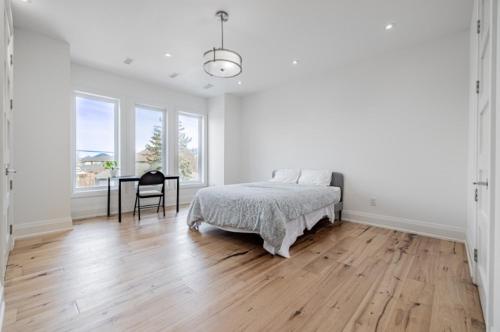 a white bedroom with a bed and a desk at Executive Room in Toronto next to Yorkdale shopping centre in Toronto
