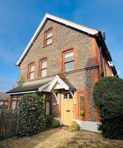a red brick house with a yellow door at Fairview House in Sheringham