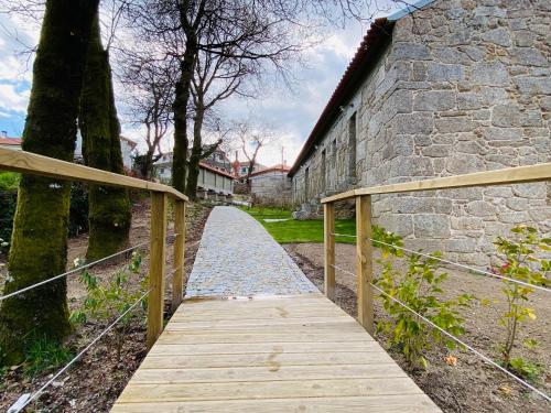 a wooden walkway next to a stone building at Casa da Fonte de Cima in Celorico de Basto