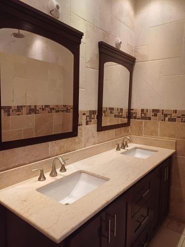 a bathroom with two sinks and a large mirror at The president room 5 minutes to Devon House 4 Waterloo Avenue Kingston in Kingston